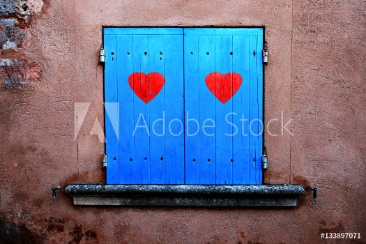 Picture of Old blue colored closed window shutters details with illustrated two red hearts